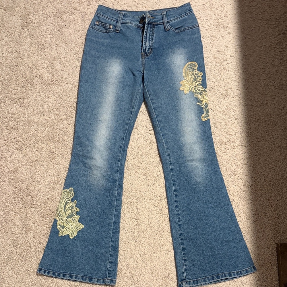 Embroidered Blue midrise flare Jeans with floral designs on them